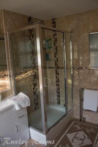 a shower with a glass door in a bathroom at Ruxley Rooms in Sidcup