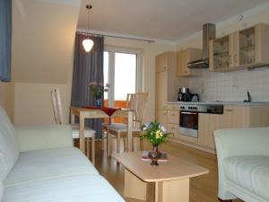ein Wohnzimmer und eine Küche mit einem Sofa und einem Tisch in der Unterkunft Ferienhof Lilienstein in Bad Schandau