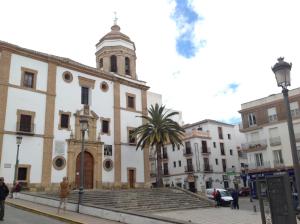 a building with a clock tower on a city street at Apartamento Royal Centro de Ronda in Ronda