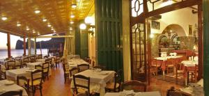 a restaurant with tables and chairs in a room at Hotel La Certosa in Massa Lubrense