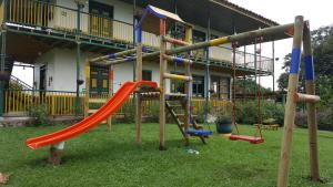 a playground in front of a house with a slide at Finca Hotel el Palmar in Montenegro