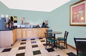 un restaurante con mesa, sillas y barra en Super 8 by Wyndham Carlisle-South en Carlisle