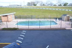 a swimming pool behind a fence in a parking lot at Americas Best Value Inn Augusta Downtown in Augusta