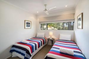 a bedroom with two beds and a window at Sunseeker Holiday Apartments in Sunshine Beach