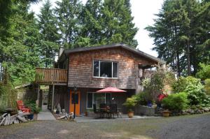 a small house with a balcony and a deck at At Nautica Tigh private keypad entrances in Qualicum Beach