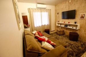 een woonkamer met een bank en een televisie bij Apartamento Aconchegante Na Serra in Gramado