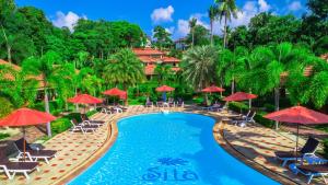 a pool at a resort with red umbrellas and chairs at Sita Beach Resort in Ko Lipe