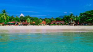 a beach with a group of resorts and the water at Sita Beach Resort in Ko Lipe