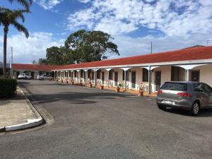a car parked in a parking lot in front of a motel at Tuncurry Beach Motel in Tuncurry