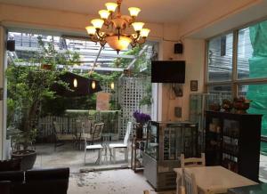 a living room with a table and chairs and a chandelier at Oriental Smile Hotel in Bangkok