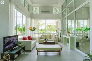 a living room with a couch and a tv at The Terrace Hotel in Nakhon Si Thammarat