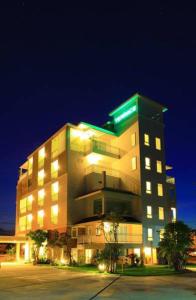 un gran edificio con techo verde por la noche en The Terrace Hotel en Nakhon Si Thammarat