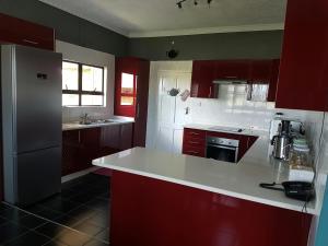 a kitchen with red cabinets and a white counter top at The Residence Chobe Villa in Kasane