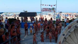 grupa ludzi stojących na plaży w obiekcie Hotel Canasta w Rimini