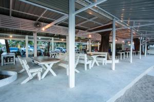 a group of tables and chairs under a building at Nisasiri Boutique Resort in Laem Sing