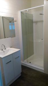 a bathroom with a sink and a shower with a glass door at Ageri Holiday Unit in Bright