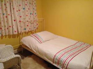 a small bedroom with a bed and a chair at Villa 44 in Camelford