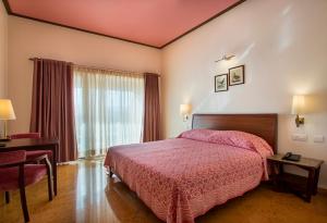 a bedroom with a bed and a desk and a window at Dera Masuda Luxury Resort in Pushkar