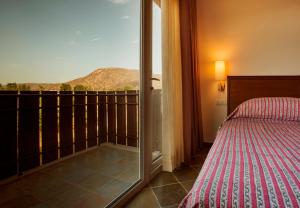 a bedroom with a bed and a balcony with a view at Dera Masuda Luxury Resort in Pushkar +31 photos
