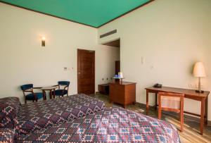 a hotel room with a bed and a desk and chairs at Dera Masuda Luxury Resort in Pushkar