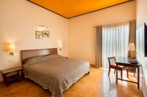 a bedroom with a bed and a table and a desk at Dera Masuda Luxury Resort in Pushkar