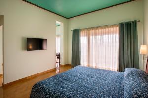 a bedroom with a blue bed and a television at Dera Masuda Luxury Resort in Pushkar