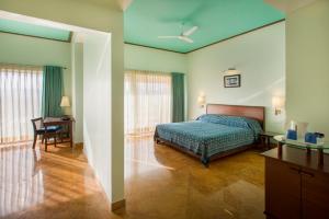 a bedroom with a bed and a desk and a table at Dera Masuda Luxury Resort in Pushkar