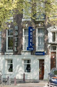 un edificio con una señal azul en la parte delantera en Family Hotel Kooyk, en Ámsterdam