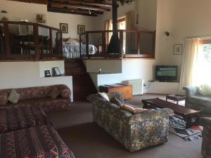 a living room with two couches and a tv at Lairds Lodge in Underberg