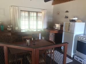 a kitchen with a table and a refrigerator at Lairds Lodge in Underberg