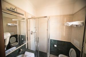 een badkamer met een douche, een toilet en een wastafel bij Hotel Donatello in Rome