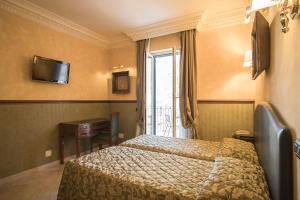 Un pat sau paturi într-o cameră la Hotel Donatello