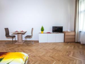 プラハにあるBeautiful Central Apartment Thámovaのリビングルーム(テレビ、テーブル、椅子付)