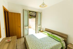una camera con letto, tavolo e finestra di Complesso Gardencasa a Torre Suda