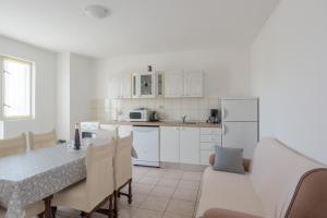 a kitchen and dining room with a table and chairs at Apartment Boja in Biograd na Moru