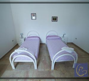 Cette chambre dispose de 2 lits violets et de parquet. dans l'établissement BB Gallipolis Terra, à Gallipoli