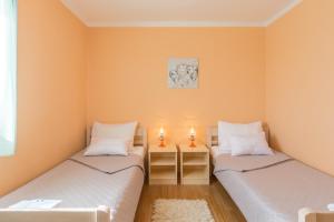 2 camas individuales en una habitación con paredes de color naranja en Apartment Boja, en Biograd na Moru