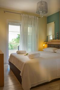 a bedroom with a large white bed with a window at Luxury Villa Efi Thasos in Chrysi Ammoudia