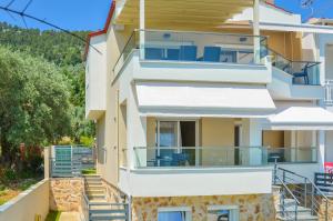een gebouw met balkons en trappen die naar het gebouw leiden bij Luxury Villa Efi Thasos in Chrysi Ammoudia