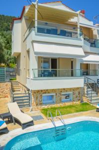 een villa met een zwembad en een huis bij Luxury Villa Efi Thasos in Chrysi Ammoudia
