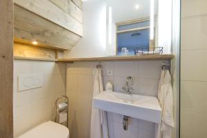 een badkamer met een wastafel, een toilet en een spiegel bij Sautille2 in Zandvoort