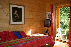 ein Schlafzimmer mit einem Bett und einem TV an der Wand in der Unterkunft Holzhaus im Grünen B&B in Passau