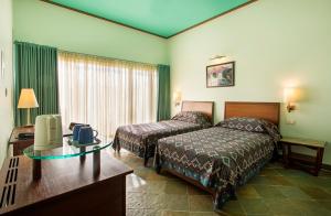 a hotel room with two beds and a television at Dera Masuda Luxury Resort in Pushkar