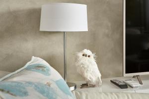 uma coruja branca sentada numa mesa ao lado de uma lâmpada em Tamar River Apartments em Rosevears