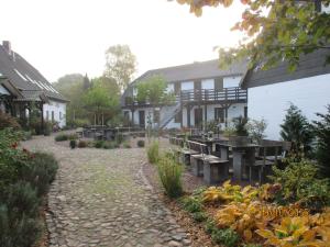 a garden in front of a house with a patio at Landhotel Belitz Garni in Küsten