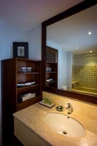 a bathroom with a sink and a large mirror at D'Sriwing Villa Gallery in Kuta