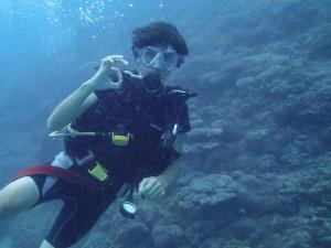 a person is taking a picture in the water at Blue Monkey Beach Cottages in Wasini