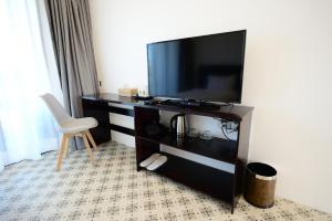 a hotel room with a television and a chair at SakSukSmile Resort in Sukhothai