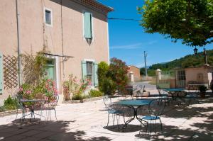 a patio with tables and chairs in front of a building at Mas la Cigaliere in Venasque