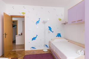 um quarto com uma cama com golfinhos azuis na parede em Apartments Oliva em Cavtat
